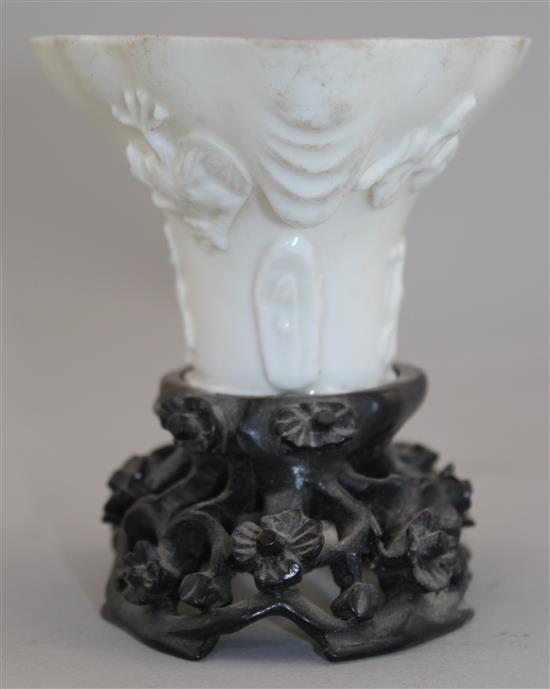 A Chinese Dehua blanc-de-chine libation cup, late 17th / early 18th century, 13cm, carved wood stand